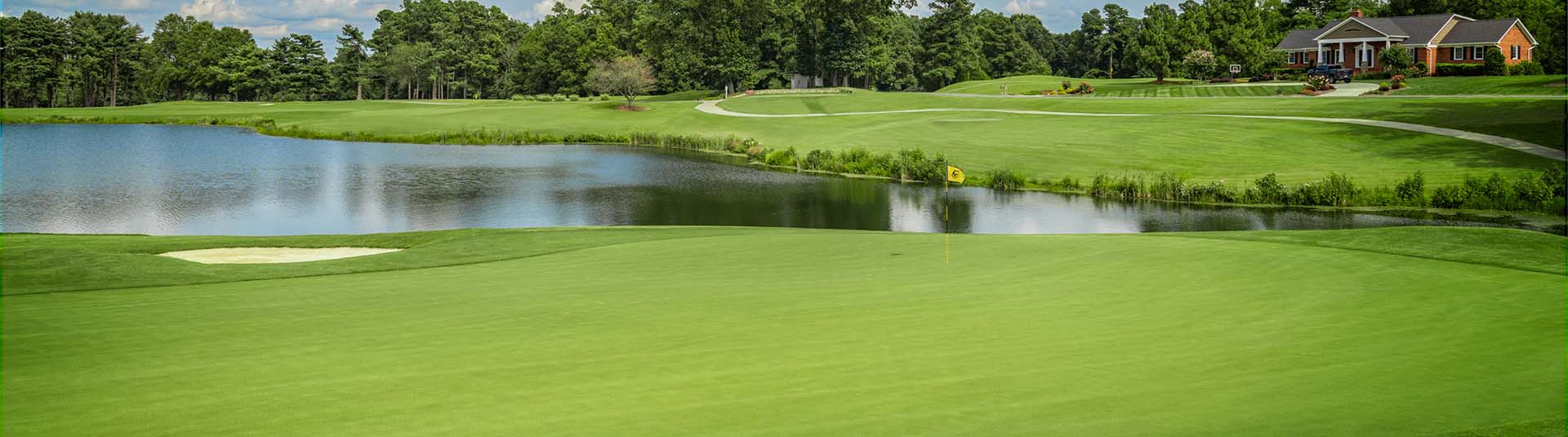 View of course greens and a lake